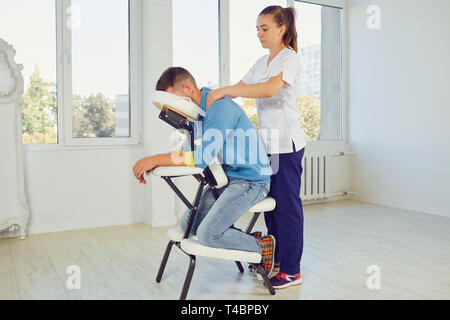 Woman massaging man au stand spécial Banque D'Images