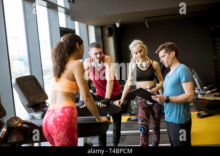 Groupe de jeunes gens de parler de sport dans un gymnase après une séance Banque D'Images