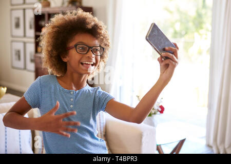 Fille préadolescente filmer elle-même chanter à l'aide d'une app de médias sociaux sur son smartphone, Close up Banque D'Images