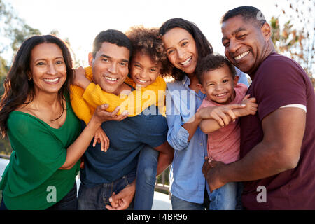 Mixed Race family jouer ensemble dans le jardin, souriant à l'appareil photo Banque D'Images