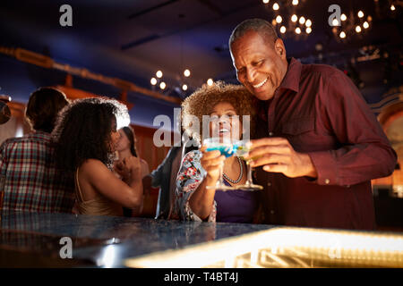 Portrait of Senior Couple boire et danser au bar Banque D'Images