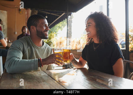 Jeune couple rencontre à Sports Bar bénéficiant d''un verre avant le match Banque D'Images