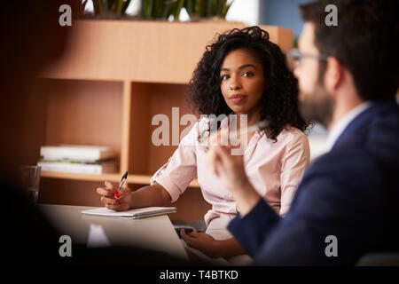 Businesswoman Making Notes assis à la Table de concertation avec des collègues de bureau moderne Banque D'Images