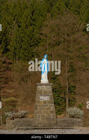 Bleu et blanc disponible à statue de Lady Mary prier, selective focus avec la nature historique de pins, trouvés sur un sentier hikin en Ardenne, Belgique Banque D'Images