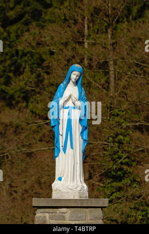 Bleu et blanc disponible à statue de Lady Mary prier, selective focus avec la nature historique de pins, trouvés sur un sentier hikin en Ardenne, Belgique Banque D'Images