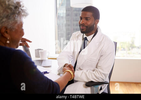 Senior Woman Shaking Hands With homme médecin chirurgien esthétique In Office Banque D'Images