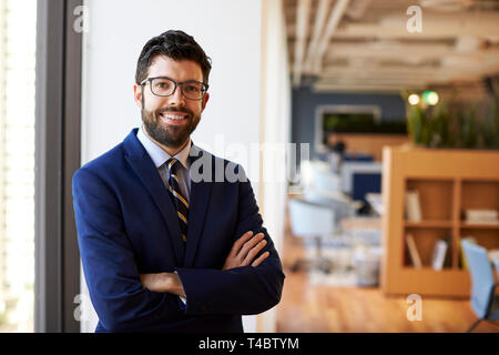 Portrait Of Businessman in Modern Office Standing By Window Banque D'Images