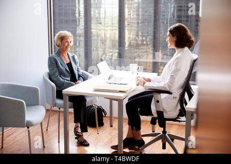 Senior Woman Having Consultation avec femme médecin à l'hôpital Office Banque D'Images