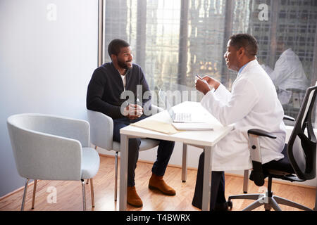 L'homme en consultation avec médecin homme dans le bureau de l'hôpital Banque D'Images