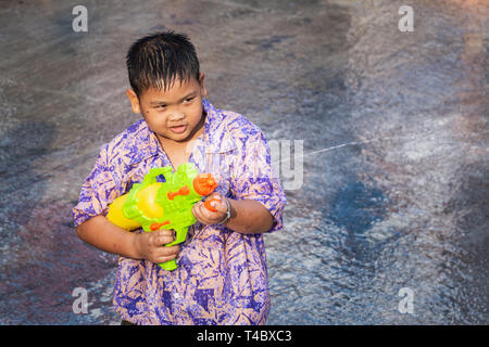 SUKHOTHAI, THAÏLANDE - 15 avril 2019 : les enfants thaïlandais le tir avec des armes à feu au cours de l'eau de Songkran Nouvel An Fête de l'eau dans la rue. Banque D'Images