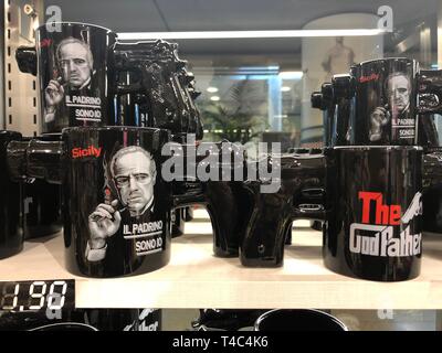 Catane, Italie. 14Th Mar, 2019. Tasse à café avec poignée pistolet, sur laquelle le portrait de l'acteur américain Marlon Brando dans Le rôle de boss de la mafia Don Vito Corleone est représenté, et de la mafia de parution 1972 film 'Le Parrain', peut être vu sur l'étagère d'un magasin de souvenirs. (Dpa KORR 'Sausage parrain' et 'Pasta' cartouche : La Mafia comme une marque) Credit : Lena Klimkeit/dpa/Alamy Live News Banque D'Images