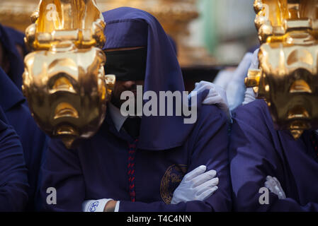 Un homme les yeux bandés est vu porter un des flotteur 'passion' la fraternité comme il prend part à une procession pendant la Semaine Sainte. En Andalousie, la Semaine Sainte est l'un des plus important et célèbre la fête religieuse de l'Espagne. Chaque année, des milliers de fidèles chrétiens célèbrent la Semaine Sainte de Pâques avec la crucifixion et la résurrection de Jésus Christ. Banque D'Images