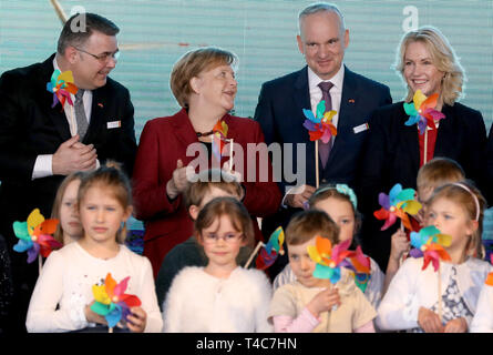 Sassnitz Mukran, Allemagne. Apr 16, 2019. Kjell Borge Freiberg (l-r), de l'Énergie Ministre Norvégien, Angela Merkel (CDU), Chancelier allemand, Johannes TEYSSEN, Eon PDG, et Manuela Schwesig (SPD), premier ministre du Mecklenburg-Vorpommern, sera sur scène avec de petites éoliennes derrière les enfants durant la mise en service officielle de la ferme éolienne offshore d'Arkona. La ferme éolienne à 35 kilomètres au nord-est de Rügen est une coentreprise de l'énergie à base d'Essen et le groupe Eon actionnaire norvégien. Equinor Crédit : Bernd Wüstneck/dpa/Alamy Live News Banque D'Images