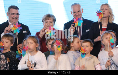 Sassnitz Mukran, Allemagne. Apr 16, 2019. Kjell Borge Freiberg (l-r), de l'Énergie Ministre Norvégien, Angela Merkel (CDU), Chancelier allemand, Johannes TEYSSEN, Eon PDG, et Manuela Schwesig (SPD), premier ministre du Mecklenburg-Vorpommern, sera sur scène avec de petites éoliennes derrière les enfants durant la mise en service officielle de la ferme éolienne offshore d'Arkona. La ferme éolienne à 35 kilomètres au nord-est de Rügen est une coentreprise de l'énergie à base d'Essen et le groupe Eon actionnaire norvégien. Equinor Crédit : Bernd Wüstneck/dpa/Alamy Live News Banque D'Images