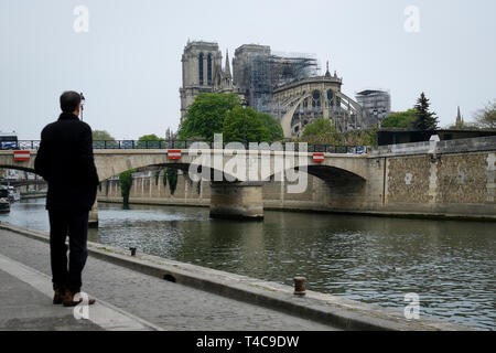 Paris, France. Apr 16, 2019. Un homme regarde la Cathédrale Notre Dame endommagé après un incendie dans le centre de Paris, capitale de la France, le 16 avril 2019. L'incendie dévastateur de la Cathédrale Notre Dame dans le centre de Paris a été publié après la gravure pendant 15 heures, les médias locaux ont rapporté mardi. Crédit : Alexandre Karmen/Xinhua/Alamy Live News Banque D'Images