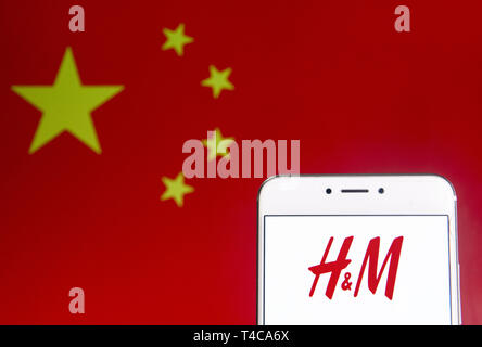 Hong Kong. 6ème apr 2019. Sur cette photo, l'illustration d'une multinationale suédoise design entreprise de vente au détail de l'habillement Hennes & Mauritz, H&M, le logo est vu sur un appareil mobile Android avec la République populaire de Chine drapeau dans l'arrière-plan. Budrul Chukrut Crédit : SOPA/Images/ZUMA/Alamy Fil Live News Banque D'Images