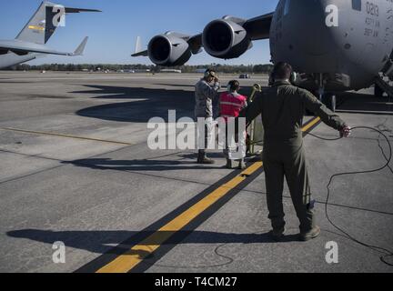 Grieger Jacob Navigant de première classe, 14e Escadron de transport aérien master charge, communique à un C-17 Globemaster III pilote à Joint Base Charleston, Caroline du Sud, le 18 mars 2019, juste avant le décollage. Les arrimeurs sont responsables de chargement correctement, la sécurité et l'escorte des marchandises et des passagers avant et après chaque vol. Banque D'Images