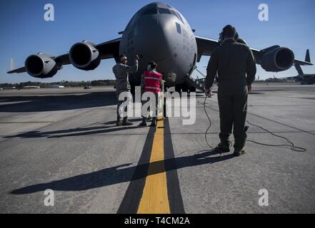 Grieger Jacob Navigant de première classe, 14e Escadron de transport aérien master charge, communique à un C-17 Globemaster III pilote à Joint Base Charleston, Caroline du Sud, le 18 mars 2019, juste avant le décollage. Les arrimeurs sont responsables de chargement correctement, la sécurité et l'escorte des marchandises et des passagers avant et après chaque vol. Banque D'Images