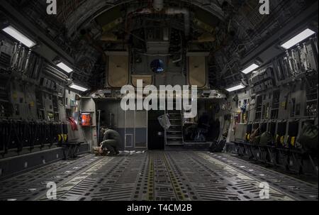 Grieger Jacob Navigant de première classe, 14e Escadron de transport aérien master charge, communique à un C-17 Globemaster III pilote à Joint Base Charleston, Caroline du Sud, le 18 mars 2019, juste avant le décollage. Les arrimeurs sont responsables de chargement correctement, la sécurité et l'escorte des marchandises et des passagers avant et après chaque vol. Banque D'Images