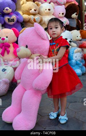 Petite fille avec de grands ours à Koh Pich theme park, Diamond Island, Phnom Penh, Cambodge Banque D'Images