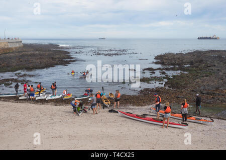 Regardant vers le bas sur un groupe de touristes de se préparer pour une excursion sur l'océan des kayaks ou canoës pendant les vacances d'été à Cape Town, Afrique du Sud Banque D'Images