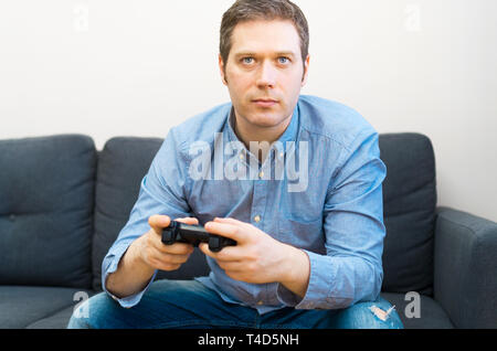 Man playing video game avec gamepad en mains. Banque D'Images