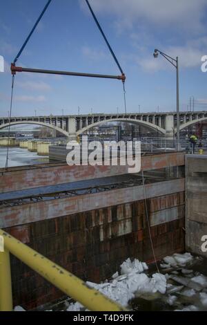 Les cloisons, enlevé à haut Saint Anthony Falls Lock - dernier obstacle dans $3 millions de mise à niveau : les équipes d'un entrepreneur ascenseurs cloisons en acier sur le côté amont de l'écluse St. Anthony Falls le 20 mars, une manœuvre délicate remplie d'avance des débits élevés résultant de la fonte de neige dans le cours supérieur du Mississippi. Depuis près de deux semaines, personnel de l'écluse et le personnel de l'entretien et la réparation de l'article cassé des monticules de glace qui avait accumulé au-dessous les cloisons pour assurer la portes à onglet et tainter gate étaient opérationnels et les cloisons ne colle pas lors de leur élimination par le biais d'un cr Banque D'Images