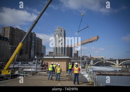 Les cloisons, enlevé à haut Saint Anthony Falls Lock - dernier obstacle dans $3 millions de mise à niveau : les équipes d'un entrepreneur ascenseurs cloisons en acier sur le côté amont de l'écluse St. Anthony Falls le 20 mars, une manœuvre délicate remplie d'avance des débits élevés résultant de la fonte de neige dans le cours supérieur du Mississippi. Depuis près de deux semaines, personnel de l'écluse et le personnel de l'entretien et la réparation de l'article cassé des monticules de glace qui avait accumulé au-dessous les cloisons pour assurer la portes à onglet et tainter gate étaient opérationnels et les cloisons ne colle pas lors de leur élimination par le biais d'un cr Banque D'Images