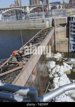 Les cloisons, enlevé à haut Saint Anthony Falls Lock - dernier obstacle dans $3 millions de mise à niveau : les équipes d'un entrepreneur ascenseurs cloisons en acier sur le côté amont de l'écluse St. Anthony Falls le 20 mars, une manœuvre délicate remplie d'avance des débits élevés résultant de la fonte de neige dans le cours supérieur du Mississippi. Depuis près de deux semaines, personnel de l'écluse et le personnel de l'entretien et la réparation de l'article cassé des monticules de glace qui avait accumulé au-dessous les cloisons pour assurer la portes à onglet et tainter gate étaient opérationnels et les cloisons ne colle pas lors de leur élimination par le biais d'un cr Banque D'Images