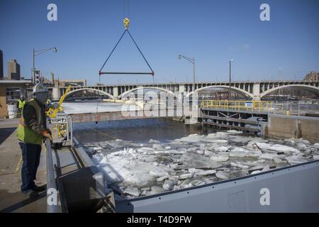 Les cloisons, enlevé à haut Saint Anthony Falls Lock - dernier obstacle dans $3 millions de mise à niveau : les équipes d'un entrepreneur ascenseurs cloisons en acier sur le côté amont de l'écluse St. Anthony Falls le 20 mars, une manœuvre délicate remplie d'avance des débits élevés résultant de la fonte de neige dans le cours supérieur du Mississippi. Depuis près de deux semaines, personnel de l'écluse et le personnel de l'entretien et la réparation de l'article cassé des monticules de glace qui avait accumulé au-dessous les cloisons pour assurer la portes à onglet et tainter gate étaient opérationnels et les cloisons ne colle pas lors de leur élimination par le biais d'un cr Banque D'Images