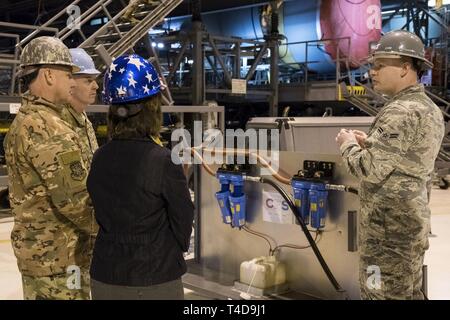 Sur la droite, d'un membre de la 1re classe Joshua Cummings, 436e Escadron de maintenance aéronautique apprenti, explique au major général Sam Barrett, commandant de l'Armée de l'air 18e, sa femme Kelly et chef Master Sgt. Chris Simpson, 18e chef du commandement de la Force aérienne, Scott Air Force Base, dans l'Illinois, la façon dont le système de filtration Childers a été développé et est utilisé dans la station d'isochrones C-5M 20 mars 2019, sur la base aérienne de Dover, Delaware le CFS a été l'innovation d'un ancien dock iso qui supprime les petites quantités de lubrifiants en aérosol de la durit d'air d'un compresseur d'air MC-7 lorsqu'utilisée pour mettre les conduits d'air de l'avion. Banque D'Images