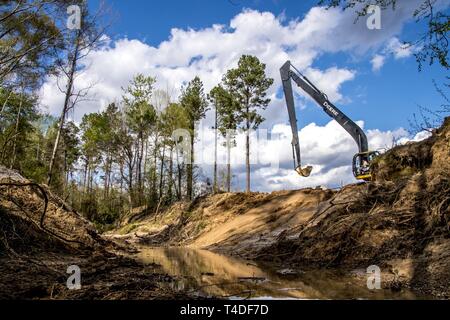 Tech. Le Sgt. Andrew Lesher exploite une excavatrice pour creuser les fondations d'un pont, 25 mars 2019, tout en travaillant à l'Ohio Air National Guard, 200e Escadron Cheval Rouge, déployée pour un projet de formation de l'état de préparation de l'innovation au Camp Kamassa, Crystal Springs, MS., aider à construire un camp spécialisé pour enfants ayant des besoins spéciaux. Soutien aux projets de l'IRT de la communauté tout en fournissant une formation précieuse pour le cheval rouge mission fournir un, mobile, flexible et autonome de l'ingénierie de construction lourde pour la force d'aviation, de l'infrastructure de base et capacités spéciales à l'appui de l'adj Banque D'Images