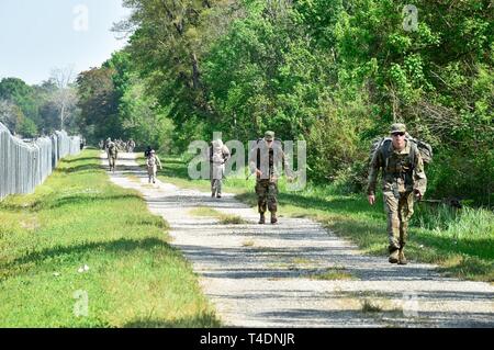 BELLE CHASSE, en Louisiane (22 mars 2019) Servicemembers stationnés dans la région de La Nouvelle-Orléans plus participer à un 12K ruck mars tout en essayant de se qualifier pour les Forces armées allemandes pour Badge de compétence militaire le 22 mars. Les Forces armées allemandes d'un insigne pour les militaires officielles est l'une des plusieurs centaines de bourses étrangères approuvées pour l'usure sur les uniformes militaires des États-Unis. Pour être admissibles, les participants sont testés dans leurs prouesses physiques, adresse au tir, les premiers soins, et les connaissances des armes nucléaires, biologiques et chimiques. Banque D'Images