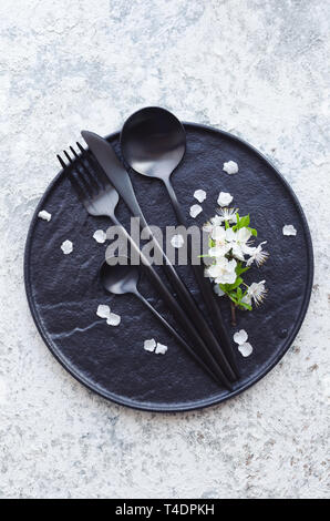 Table de printemps avec fleurs de cerisier blanc et couverts sur fond gris. La conception de la Maquette Mise en page de votre texte. Concept de jour de mères. Copier l'espace. À Banque D'Images