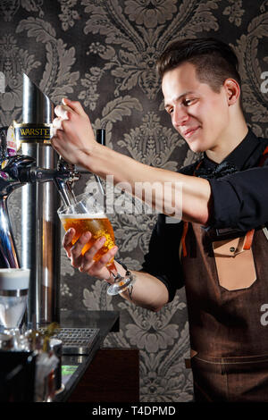 Minsk, Belarus - 02 mai 2017 : barman élégant déverse l la bière dans le verre du robinet bière bar à Londres Banque D'Images