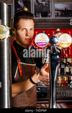 Minsk, Belarus - 02 mai 2017 : barman élégant déverse l la bière dans le verre du robinet bière bar à Londres Banque D'Images