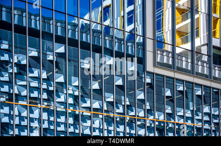 Gratte-ciel à l'architecture d'avant-garde avec garniture en verre teinté dans un cadre métallique reflète comme dans un miroir d'un bâtiment sur le côté opposé de la st Banque D'Images