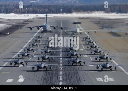 F-22 Raptors à partir de la 3e Escadre et 477th Fighter Group participent à une formation serrée avec un taxi E-3 Sentry et un C-17 Globemaster III, connu comme un éléphant à pied, le 26 mars 2019, au cours d'un exercice de la Force polaire at Joint Base Elmendorf-Richardson, en Alaska. Cet exercice de deux semaines d'escadrons donne l'occasion de démontrer leurs capacités à l'avant de déployer et de livrer combat écrasante. Banque D'Images