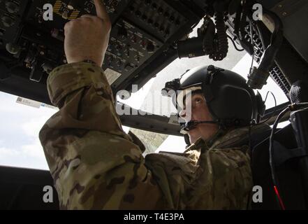 Le Lieutenant-colonel de l'Armée américaine Thomas Potter, commandant de la Garde nationale de Californie 1er Bataillon d'hélicoptères d'assaut, 140e Régiment d'aviation, effectue des vérifications avant vol UH-60M à l'intérieur d'un hélicoptère Black Hawk, le 19 mars 2019, à Los Alamitos Army Airfield, sur la base d'entraînement de forces interarmées, Los Alamitos, Californie, avant un vol d'entraînement. Le vol a donné l'occasion aux pilotes de familiarisation pratique et godet en vol avec des charges externes. Banque D'Images