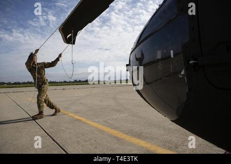 L'Adjudant de l'armée américaine, Lee Kyu un Black Hawk UH-60M avec le pilote d'hélicoptère de la Garde nationale de l'Armée de la Californie La Compagnie Bravo, 1er Bataillon d'hélicoptères d'assaut, 140e Régiment d'aviation, s'efforce d'obtenir les rotors après l'atterrissage à Los Alamitos Army Airfield après un vol d'entraînement avec deux autres pilotes, le 19 mars 2019, à base d'entraînement de forces interarmées, Los Alamitos, en Californie. Le vol a donné l'occasion aux pilotes de familiarisation pratique et godet en vol avec des charges externes. Banque D'Images