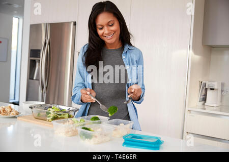 Femme dans la cuisine préparer le repas à haute teneur en protéines et de mettre dans des contenants en plastique Banque D'Images