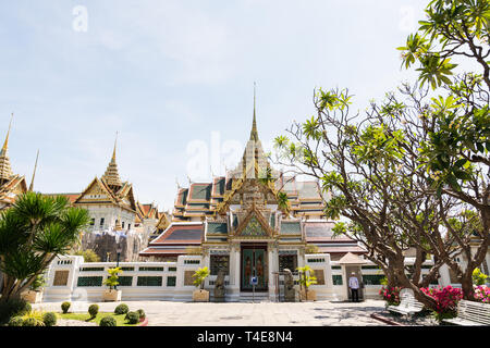 BANGKOK, THAÏLANDE - Mars 2019 - Vue sur le Grand Palais et Maha Chakri Prasat hall à travers les arbres et arbustes à sunny day Banque D'Images