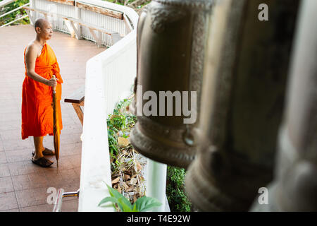 BANGKOK, THAÏLANDE - Mars 2019 : le moine bouddhiste debout à côté de la sonnerie dans le Temple du Bouddha d'or. Banque D'Images