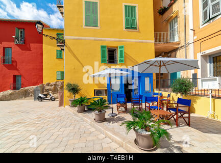 Petit restaurant en plein air et maisons colorées à Menton, France. Banque D'Images