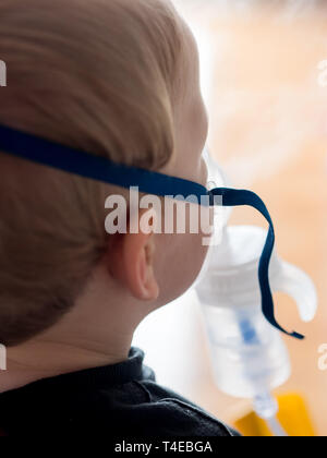 Petit garçon faire inhaliation avec masque à oxygène vue arrière Banque D'Images