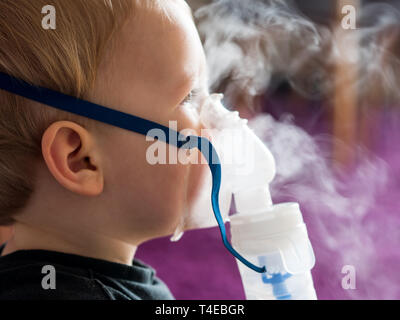 Petit garçon avec un masque à oxygène en inhalation close up Banque D'Images