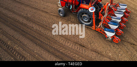 Vue aérienne de tracteur avec semoir monté d'effectuer le semis direct de cultures labourées sur domaine agricole. Farmer est l'utilisation de machines agricoles pour le plan Banque D'Images