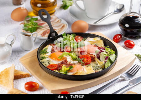 Restaurant délicieux petit déjeuner avec des œufs au plat, bacon, verts et petit camembert Banque D'Images