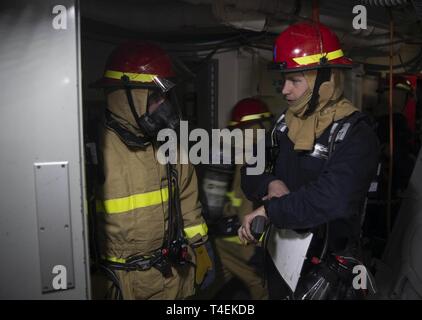 NEWPORT NEWS, Virginie (27 mars 2019) Dommage Controlman 2e classe Brandon Carric, de Palm Springs, Californie, affectés à l'USS Gerald R. Ford (CVN 78) Département de génie, fournit un retour d'un marin affecté à une station de réparation de dommages au cours d'un exercice de contrôle des dommages. Ford est actuellement en post-shakedown la disponibilité de Huntington Ingalls Industries-Newport News Shipbuilding. Banque D'Images