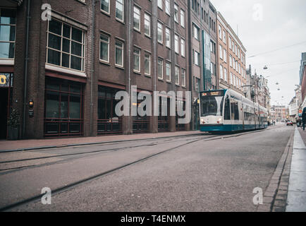 Les transports modernes à Amsterdam, Pays-Bas. Le tramway bleu et blanc dans la vieille ville. Banque D'Images